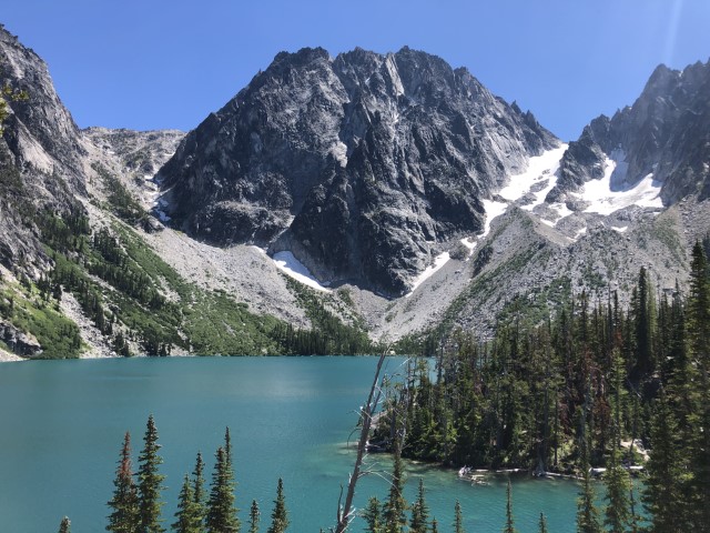 Dragontail peak flanked with hints of snow crystal-blue alpine lake. Colchuck Lake, WA