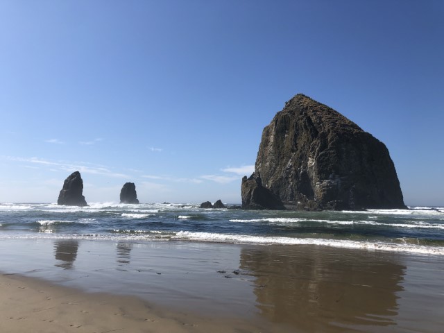 Clear skies show Haystack Rock standing tall in the Pacific Ocean. Cannon Beach, OR