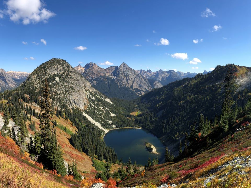 Alpine lake surrounded by autumn-colored foliage seen from the top of Maple Pass trail. North Cascades National Park, WA