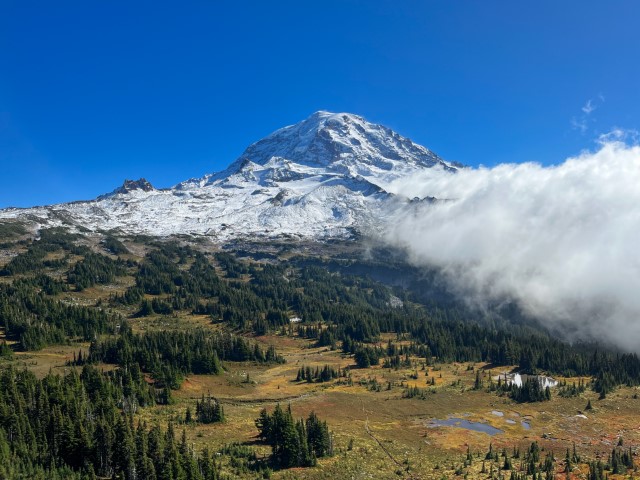 Fresh coating of snow lays on the 14,411' mountain with a hazy cloud rolling in.  Mt Rainer National Park, WA